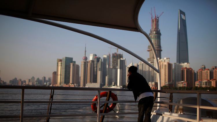 Rasant wachsende Metropole: Nachdenklich blickt dieser junge Mann über den Huangpu auf die Skyline von Shanghai.