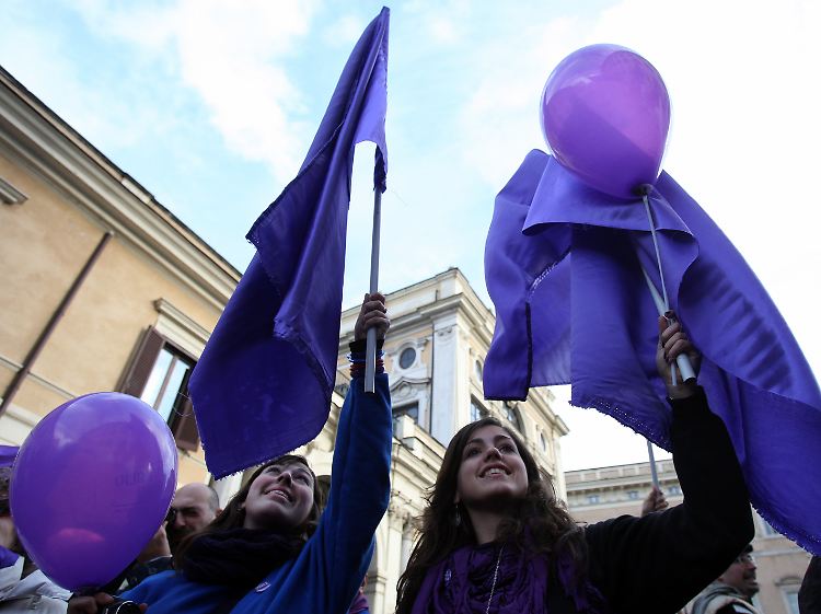 Mit violetten Outfits und Accessoires machen Berlusconi-Gegner auf sich aufmerksam.