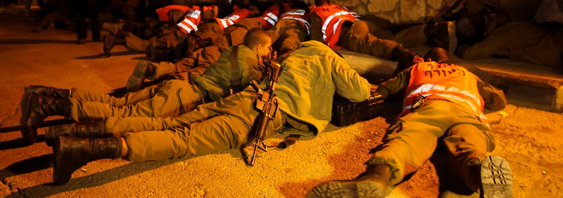 Israelische Soldaten schützen sich bei einem Raketenangriff auf die israelische Stadt Kirjat Mal'achi.