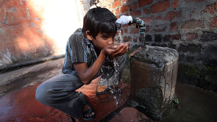 Junge im indischen Bhopal an einem Wasserhahn. Forscher warnen vor globalen Folgen des stetig absinkenden Grundwasserspiegels. Drängend sei die Lage in bestimmten Regionen von Indien, China und den USA. 