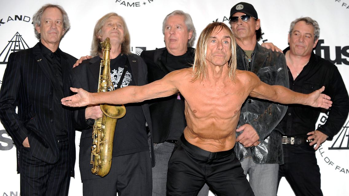 Iggy Pop (wie fast immer mit nacktem Oberkörper) mit Alt- und Neumitgliedern der Stooges: Scott Asheton (2v.r.), James Williamson (3v.l.), Scott Thurston (l), Steve Mackay (2.v.l.) und Mike Watt (r).