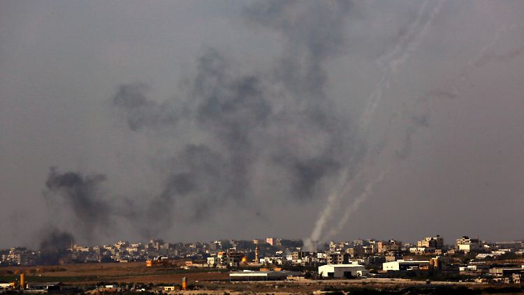 Einschläge israelischer Angriffe in Gaza-Stadt. Zugleich sind die Flugbahnen von Raketen zu sehen, die in Richtung Israel abgefeuert wurden.
