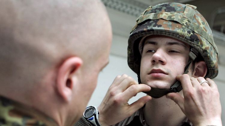 Ein Bundeswehrsoldat hilft einem Kameraden, den Helm aufzusetzen (Archivfoto).