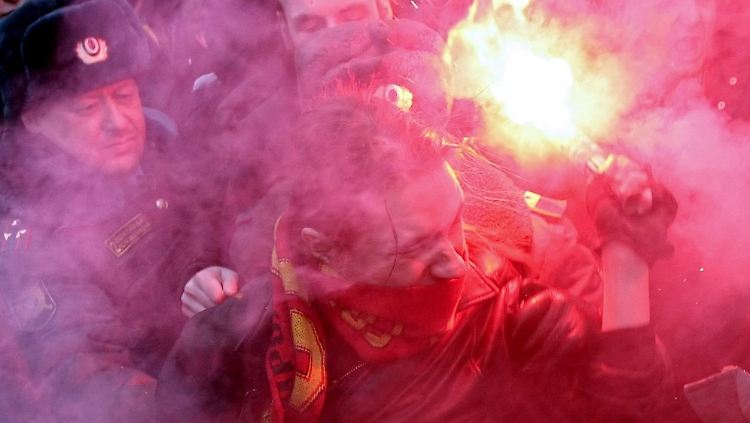 Russische Polizisten versuchen Demonstranten abzuwehren.