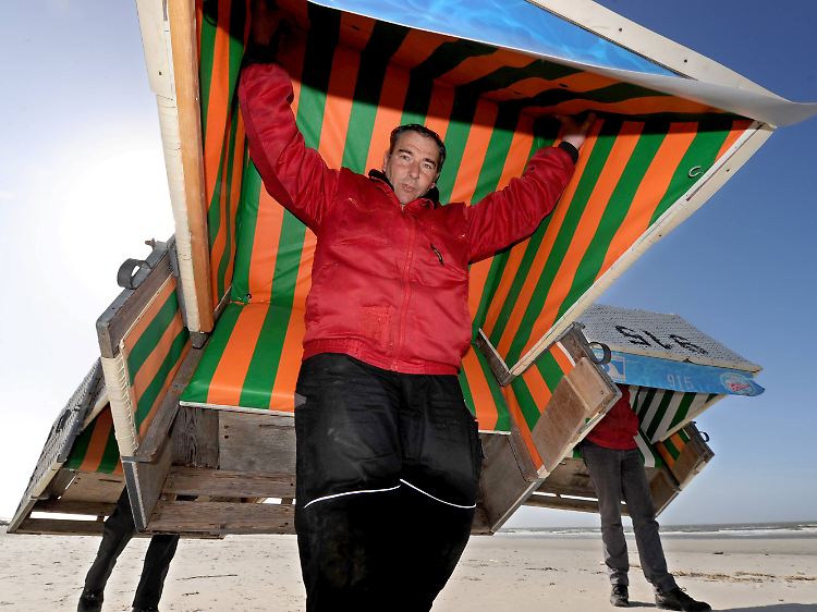 Hein-Dieter Hecke von der Tourismuszentrale St. Peter-Ording mit einem rund 80 kg schweren Strandkorb.