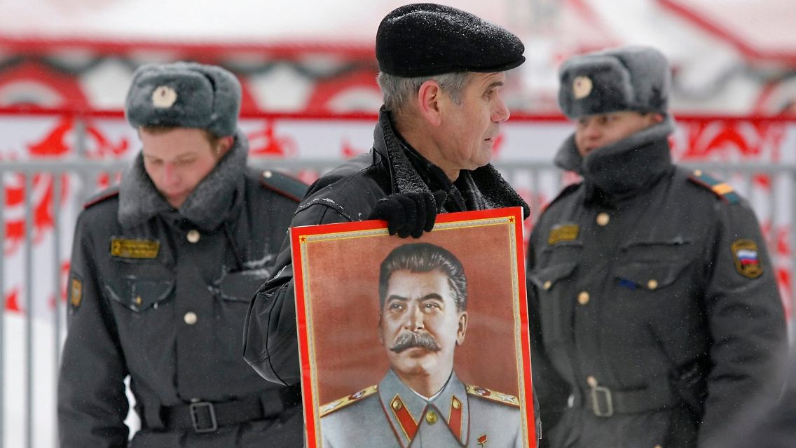 Ein russischer Stalinist mit einem Stalin-Bild am Geburtstag des Diktators auf dem Roten Platz in Moskau.
