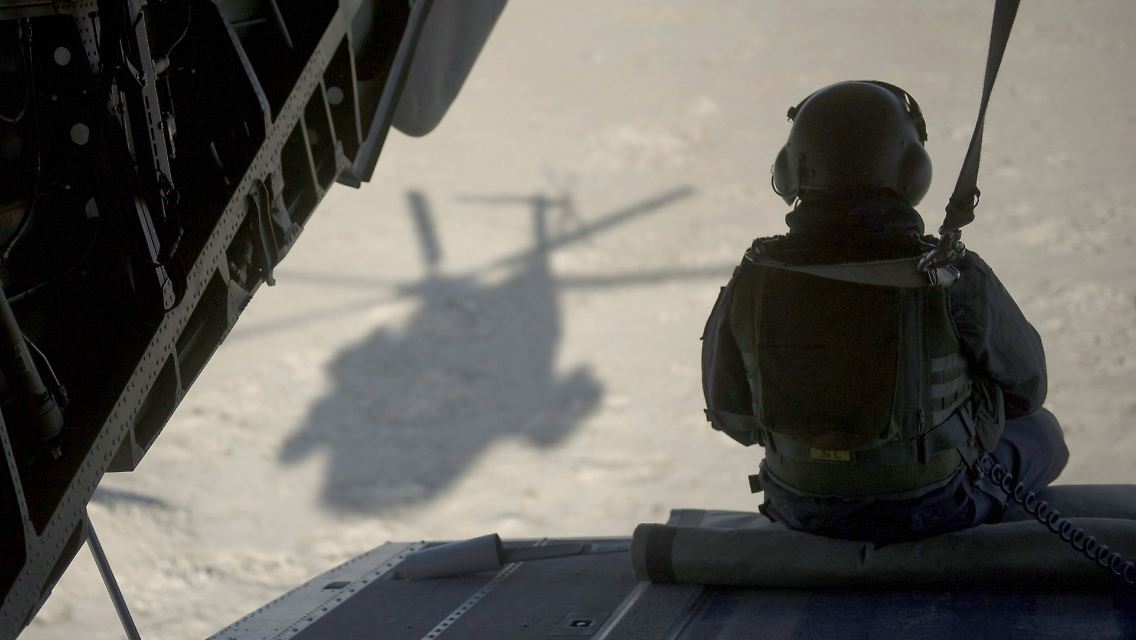 Ein Bundeswehrsoldat sitzt auf der Ladeklappe eines Bundeswehr-Hubschraubers in Afghanistan.