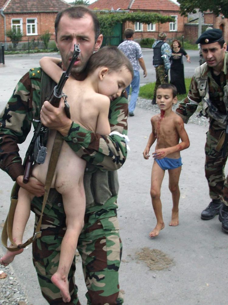Ein russischer Soldat trägt einen Jungen, der lebend der Geiselnahme an einer Schule in Beslan im südrussischen Nordossetien entkommen ist.