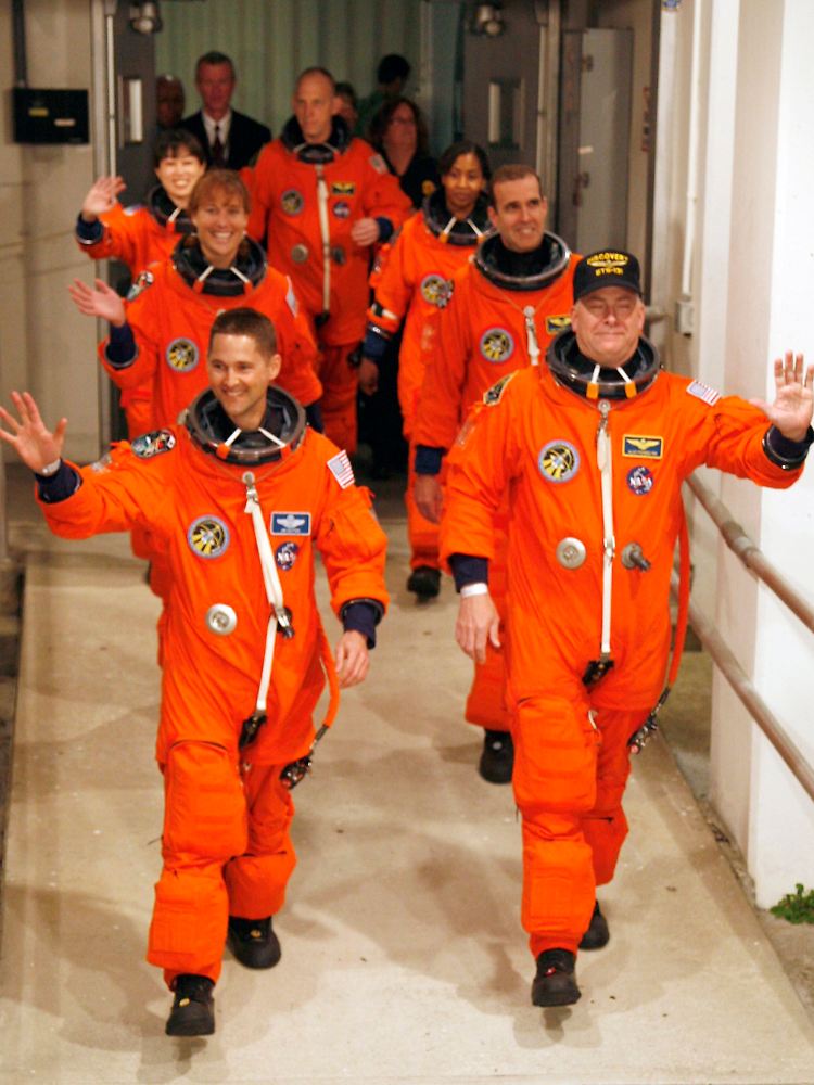 Die sieben Astronauten auf dem Weg zum Shuttle. 13 Tage lang werden sie die ISS reparieren und aufrüsten.