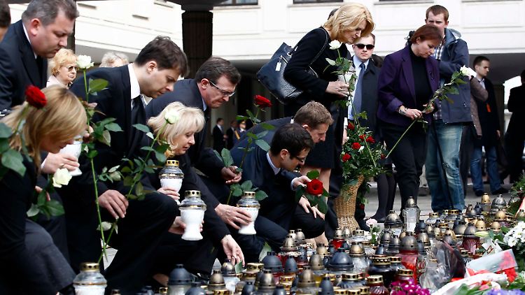 Mitglieder des polnischen Parlaments legen Blumen nieder, bevor sie in einer Trauerstunde den Toten gedenken.