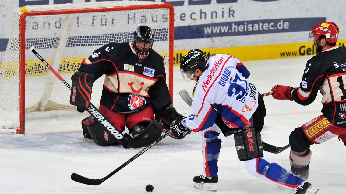 Der Torwart Travis Scott und Chris Herperger (r) von den Scorpions spielen gegen den Ingolstädter Richard Girard.