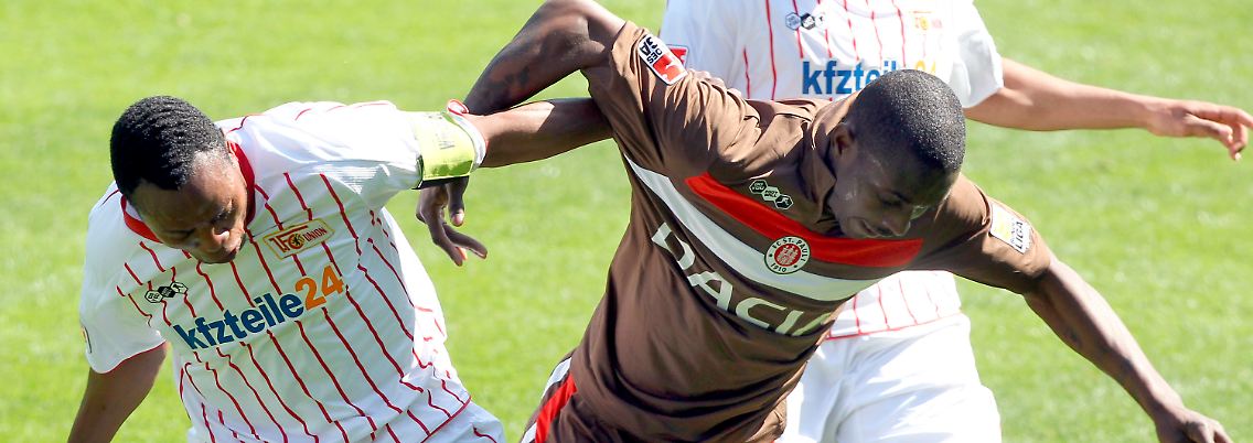 Und wieder war er hart umkämpdt: Der Berliner Macchambes Younga-Mouhani, links, und Charles Takyi vom St. Pauli bemühen sich den Ball.