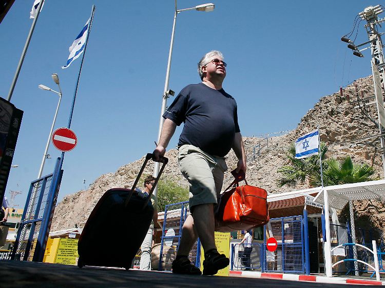 Ein Tourist überquert in Eilat die Grenze zwischen Ägypten und Israel.