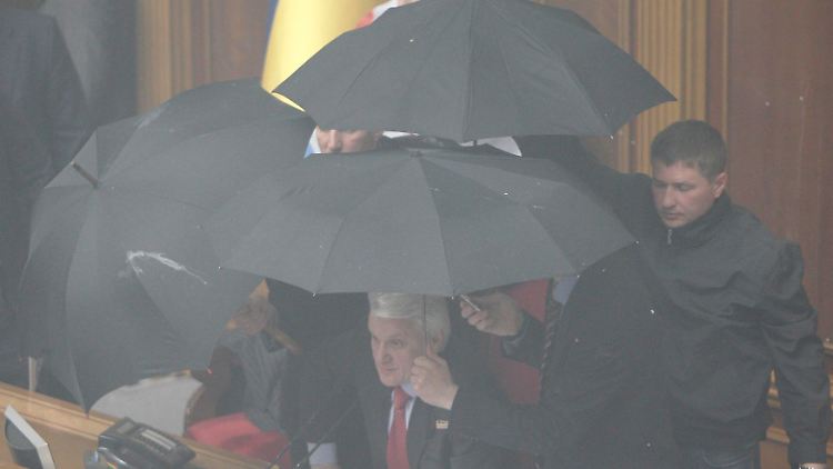 Litwin sucht Schutz unter Regenschirmen.