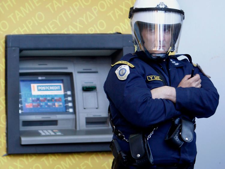 Ein Polizist vor einem Geldautomaten in Athen: Die EU-Staaten müssen sich gegenseitig besser kontrollieren, fordert Beys.