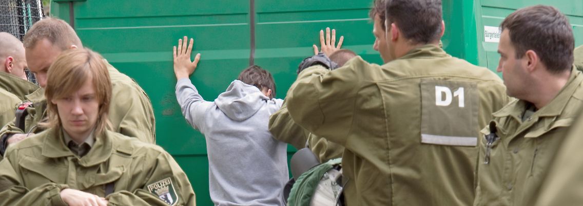 Nahe dem Kurfürstendamm in Berlin haben sich am 1. Mai Anhänger rechter Gruppen versammelt, die von Polizeibeamten am Weitergehen gehindert werden.