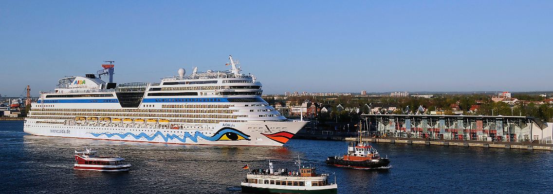 Begleitet von kleineren Schiffen und Jachten läuft die "AIDAblu" den Hafen von Warnemünde an.