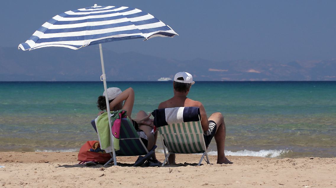 Touristen am Strand bei Loutra Kilini im Westen der Halbinsel Peloponnes.