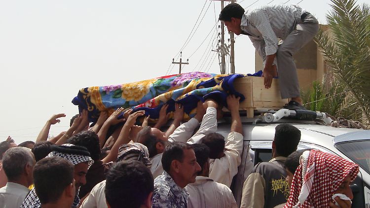 Bewohner von Suwaira (50 Kilometer südlich von Bagdad) hieven den Sarg eines Opfers der Anschläge in einen Kleinbus.