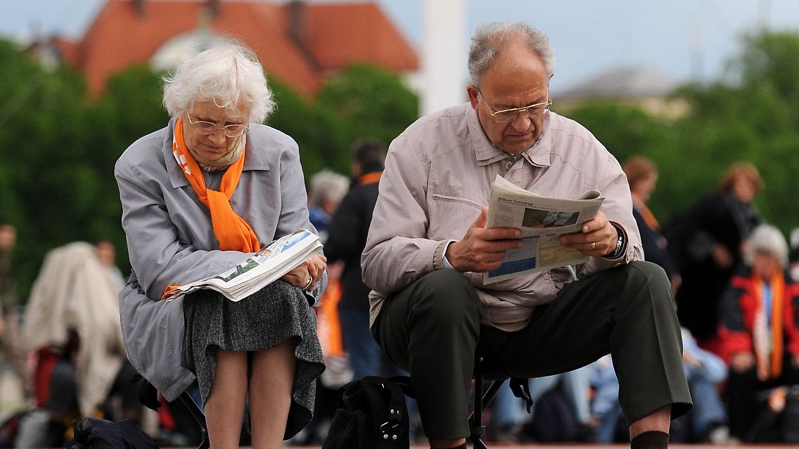 Ein Ehepaar wartet auf den Beginn des Eröffnungsgottesdienstes.