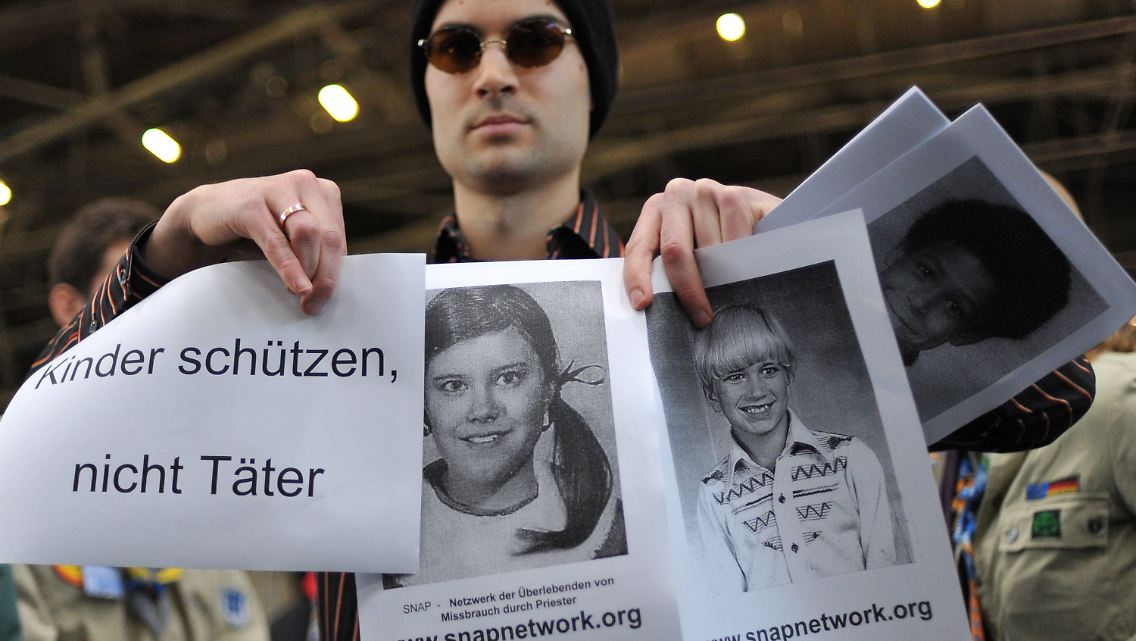 Ein Aktivist des Netzwerks Snap mit den Handzetteln, die beim Kirchentag verteilt wurden.