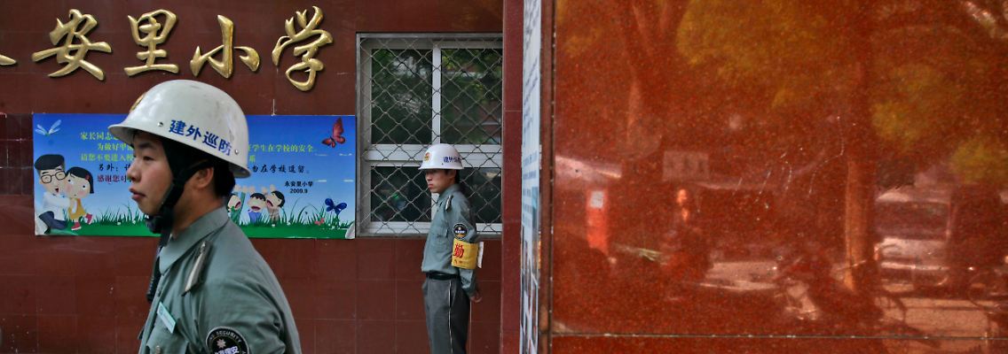 Sicherheitskräfte stehen vor einer Pekinger Grundschule Wache.