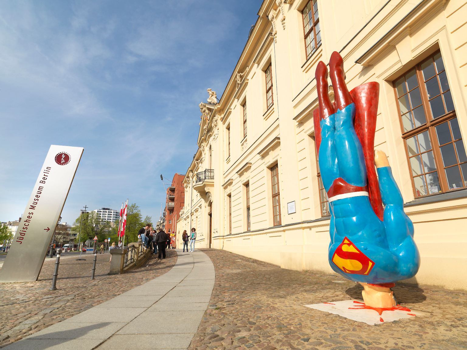 Was ist nur im Jüdischen Museum Berlin los? Superman steckt kopfüber im Gehweg.