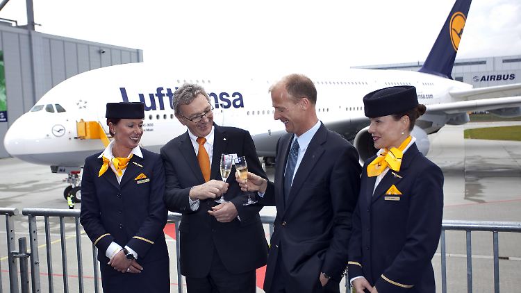 Umringt von zwei Flugbegleiterinnen stoßen Lufthansa-Chef Mayrhuber (l.) und Airbus-Chef Enders auf die Übergabe an.