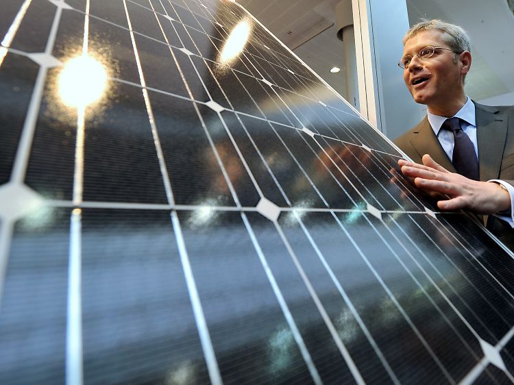 Bundesumweltminister Norbert Röttgen betrachtet auf seinem Rundgang über die Hannover-Messe ein Solar-Modul.