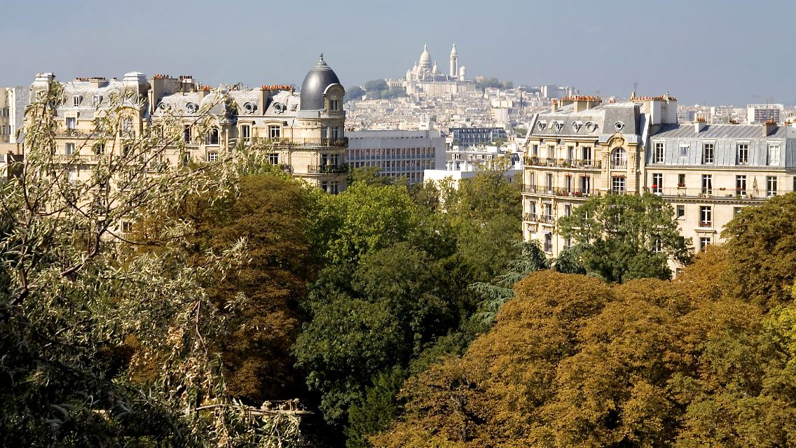 Von den Chaumont-Hügeln haben Wanderer einen eindrucksvollen Blick auf Paris und Montmartre mit der Basilika Sacré-Coeur.