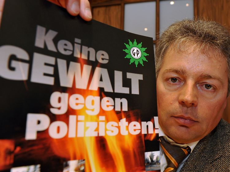 Der niedersächsische Vorsitzende der Gewerkschaft der Polizei, Bernhard Witthaut, mit einem Plakat auf einer Pressekonferenz in Hannover.