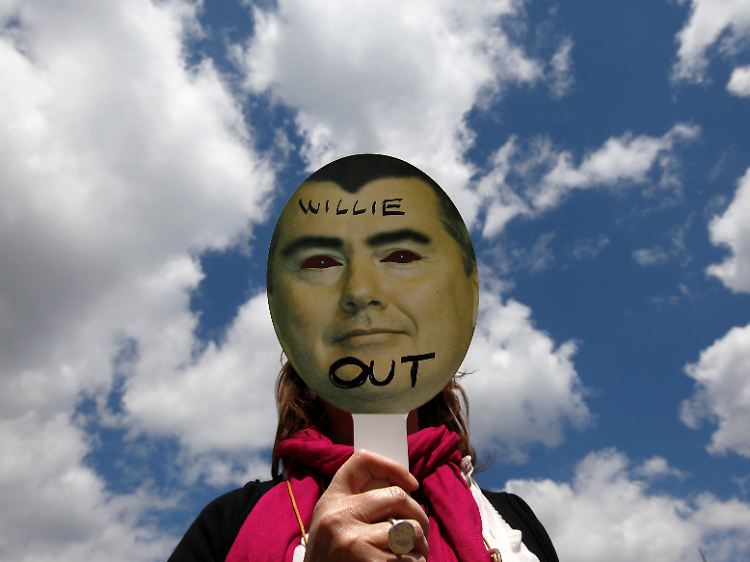 Ein Streikender hält sich ein Schild mit dem Konterfei von BA-Chef Wilie Walsh vors Gesicht.