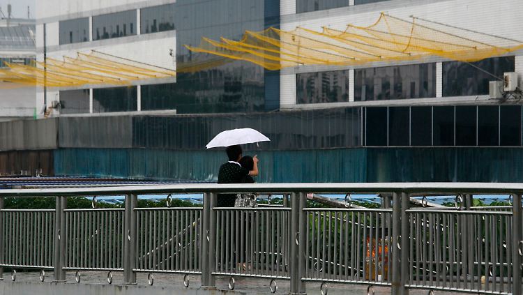 Ein Pärchen betrachtet die Auffangnetze am Foxconn-Gebäude in Longhua in der Sonderwirtschaftszone Shenzhen.