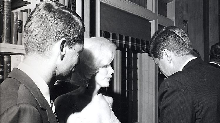 Marilyn Monroe mit Präsident John F. Kennedy (r.) und dessen Bruder Robert (l.).
