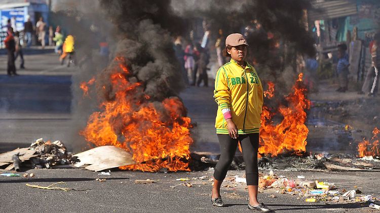 Noch einen Tag vor Eröffnung der WM protestierten Bewohner des Township Khayelitsha bei Kapstadt gegen die unzureichenden Hilfen der Regierung. Kinder nutzten die gesperrte Straße, um Fußball zu spielen.