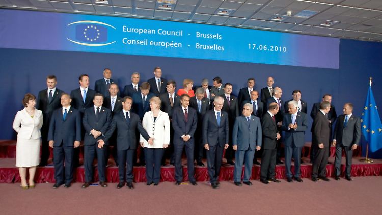 Gruppenbild. Der rote Punkt in der Mitte ist Angela Merkel.