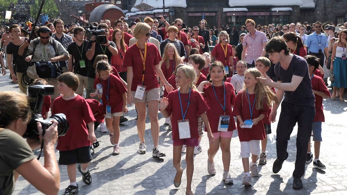 Daniel Radcliffe (r) inmitten von Kindern bei der Eröffnung der "Wizarding World of Harry Potter".