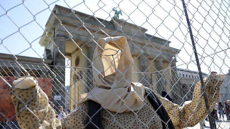 Bei einem Aktionstag von "Reporter ohne Grenzen" zum "Internationalen Tag der Pressefreiheit" am 3. Mai stehen und sitzen Kleider ohne menschlichen Inhalt  vor dem Brandenburger Tor in Berlin hinter einem Zaun (Archivbild vom (2. Mai 2009).