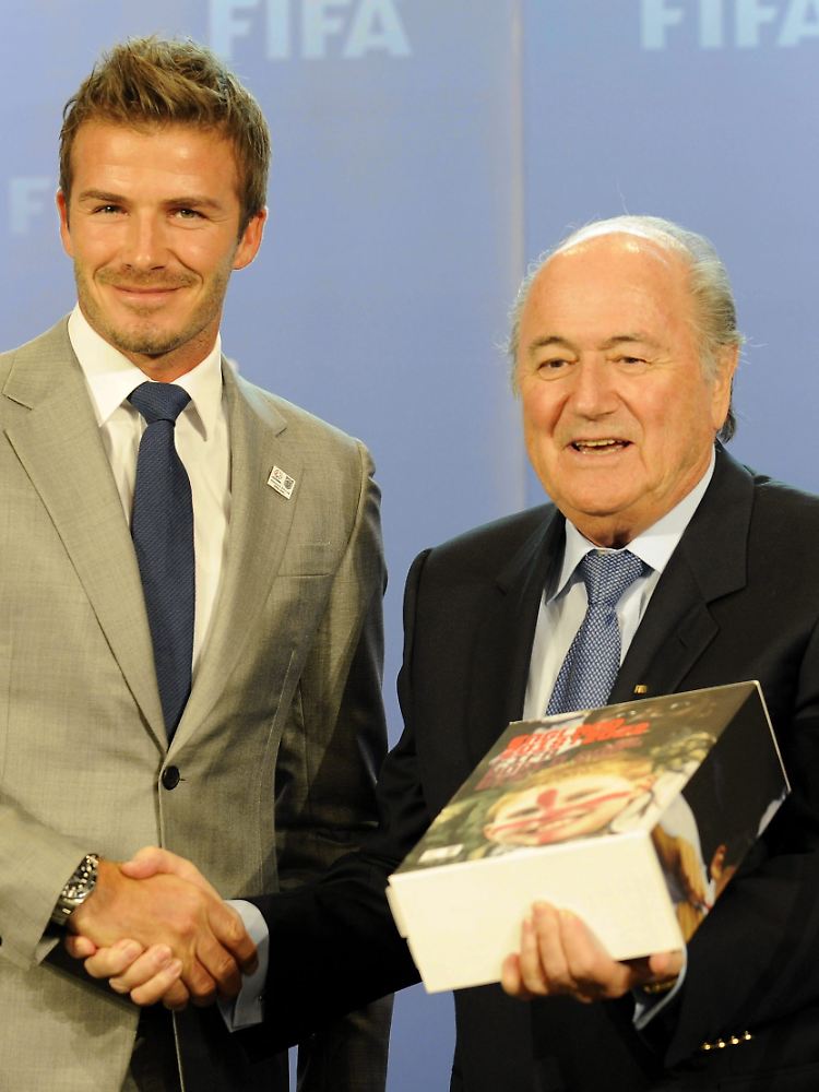 Für die Bewerbung als Austragungsort der Fußball-WM 2018 übergibt David Beckham ein schwergewichtiges Werk an FIFA-Präsident Joseph Blatter.