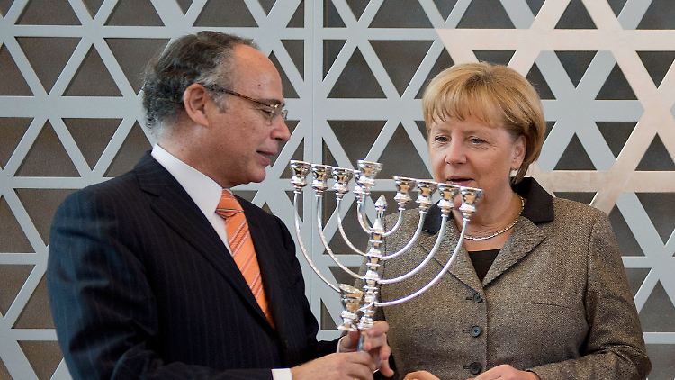 Graumann überreicht Merkel einen Chanukka-Leuchter.