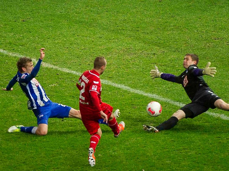 Berlins Fabian Lustenberger (v.l.), Kölns Miso Brecko und Berlins Torwart Thomas Kraft kämpfen um den Ball.