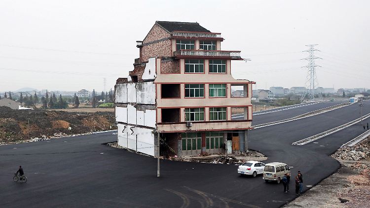 In China werden die Autobahnen einfach um Häuser herum gebaut.