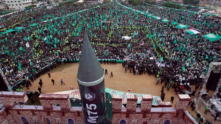 Zehntausende Hamas-Anhänger feiern den Geburtstag der Organisation. Exil-Führer Maschaal entsteigt einer Raketen-Attrappe.