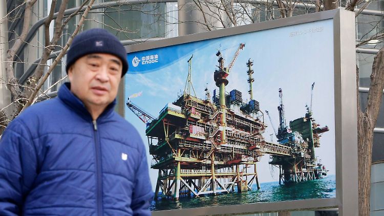 Zufällig ins Bild gelaufen: In Peking wirbt der staatliche Ölkonzern China National Offshore Oil Corp (CNOOC) vor seiner Zentrale mit großformatigen Bildern für die verstärkte Ölförderung.