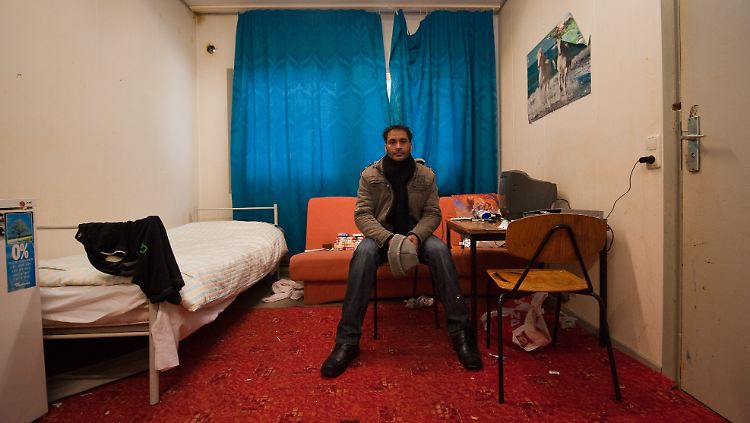 Bescheidener Wohnraum: Ein Asylbewerber aus Indien sitzt in seinem Zimmer in Bad Belzig.