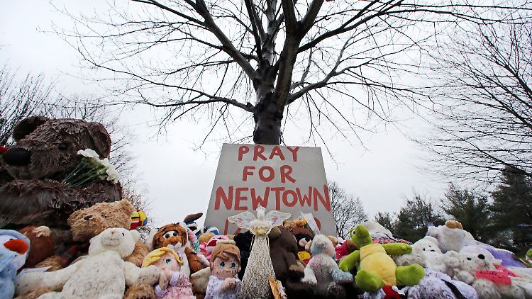 "Betet für Newtown" steht auf einem von Stofftieren umgebenen Schild nahe des Friedhofs der Stadt.
