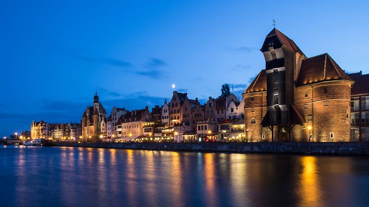 Das 1444 erbaute gotische Krantor in der Altstadt Danzigs ist eines der Wahrzeichen der Stadt - und erstrahlt auf diesem Bild in Bernstein-farbenem Licht.