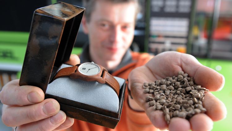 Christian Anselment, Ingenieur beim Institut für Chemische Technologie (ICT) in Pfinztal zeigt ein Uhrengehäuse und die Verpackung, die aus dem Bio-Kunststoff "Arboform" hergestellt sind. Rechts ist das Granulat des Kunstoffes zu sehen.