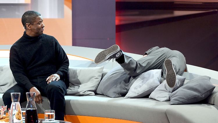 Ralf Schmitz scheint etwas zu suchen, Denzel Washington sieht zu.