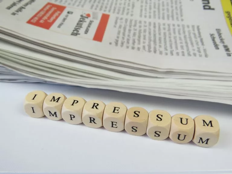 Das Wort âImpressumâ ist buchstabiert. Die Buchstaben befinden sich auf kleinen Würfel